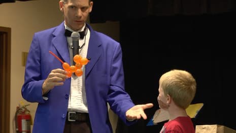 A young child's balloon animal performs silly magic tricks with a magician!